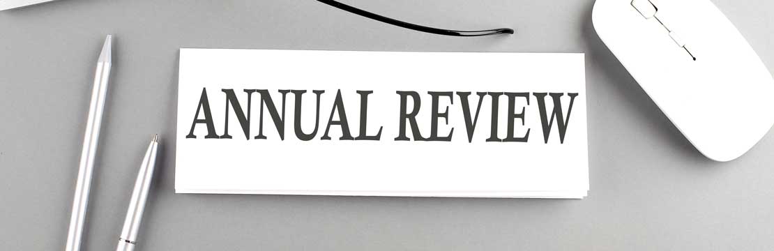 “Annual Review” text on a paper with keyboard on grey background